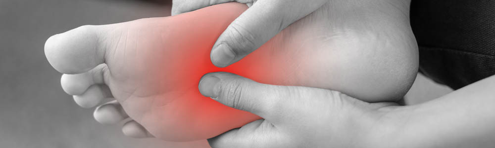 Black and white close-up of the bottom of a foot with highlighted red section demonstrating where the person is experiencing pain